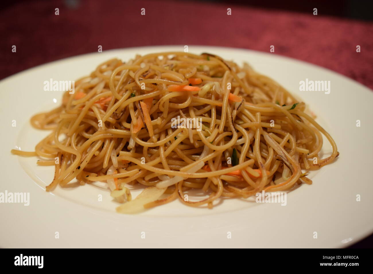 Plat de nouilles chinoises lo mein avec carottes et oignons sur une assiette blanche Banque D'Images