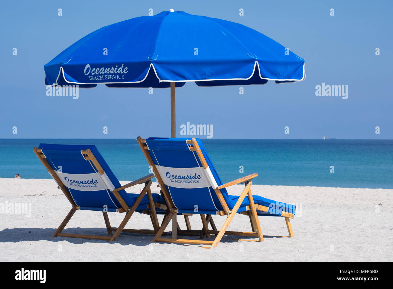 Détendez-vous à Delray Beach en Floride sur le sable, sous un parasol, de chaises longues à la recherche à la mer bleue. Banque D'Images