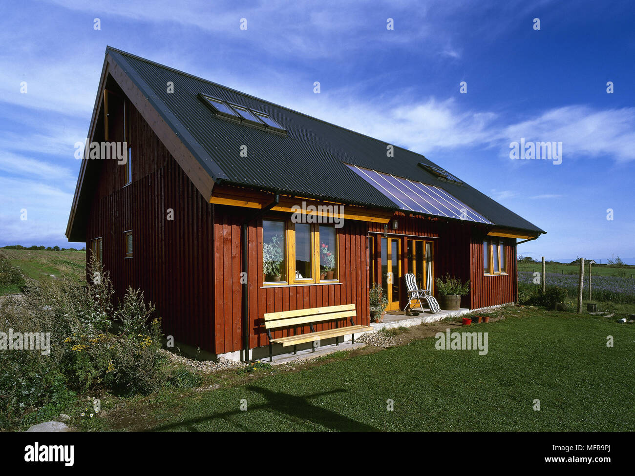 Vue extérieure d'un chalet en bois avec toiture lanterneaux et pelouse. Banque D'Images
