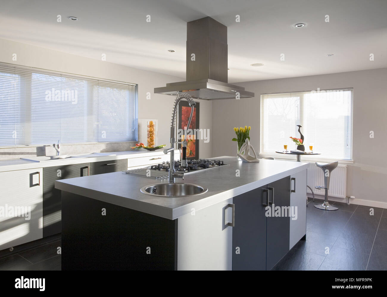 Une hotte au-dessus de l'île centrale de l'unité situé dans une plaque de cuisson et évier en cuisine contemporaine Banque D'Images