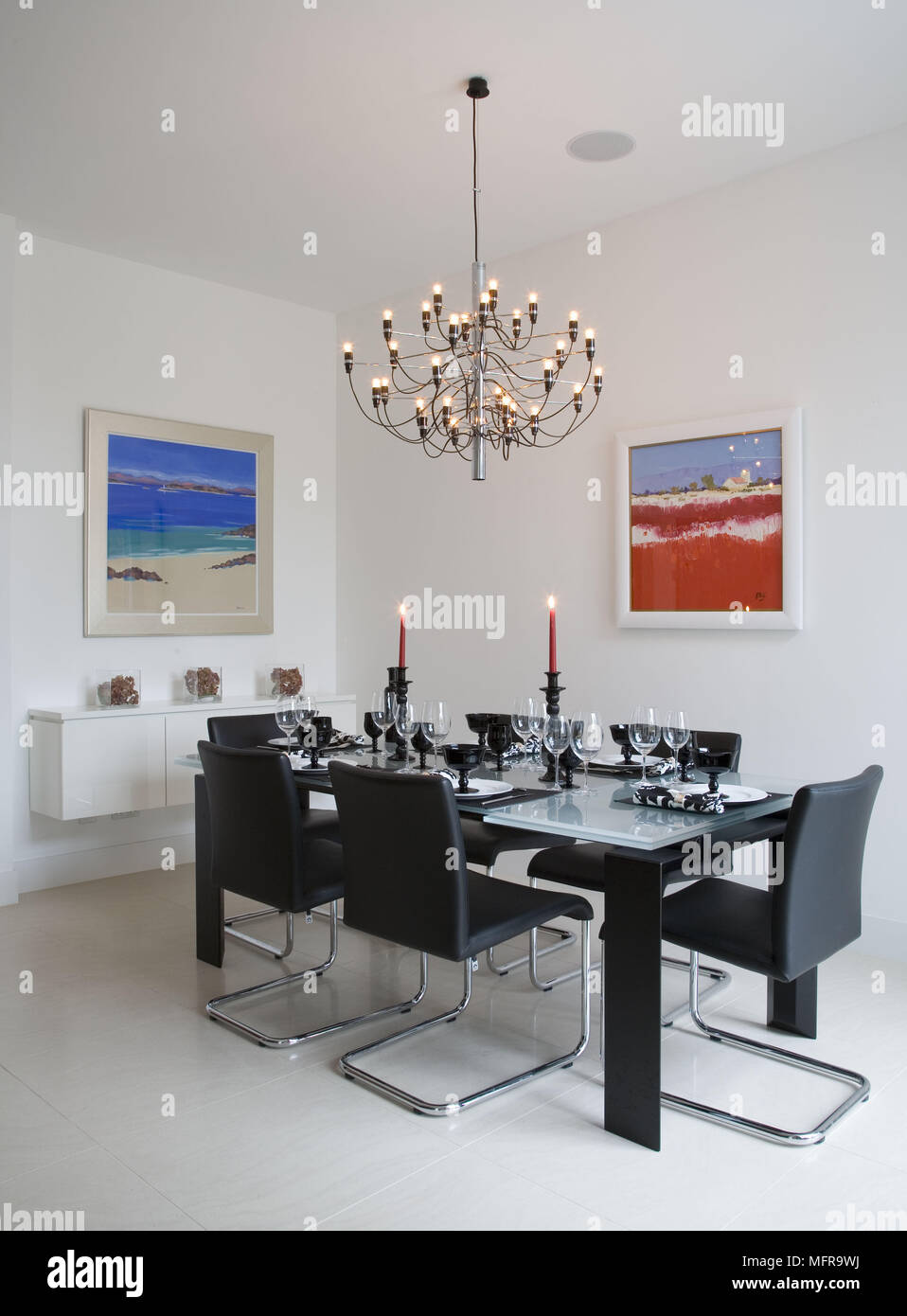 Lustre allumé au-dessus de table en verre et chaises en cuir et chrome  salle à manger contemporaine Photo Stock - Alamy