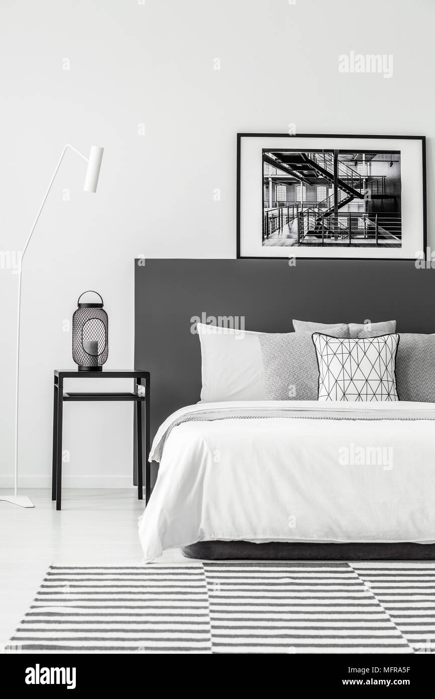 Tableau noir à côté d'un lit à baldaquin blanc en un minimum d'intérieur  chambre à coucher avec tapis Photo Stock - Alamy