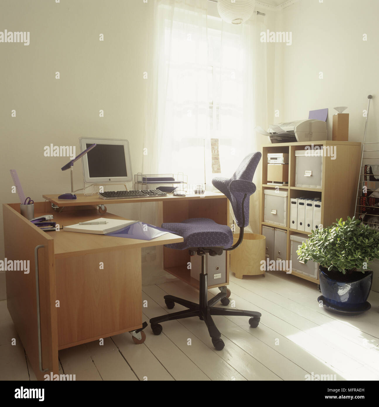 Un détail d'un bureau à domicile espace de travail avec une table en bois  et classeur un ordinateur d'un président et d'une plante en pot sur un  parquet en bois Photo Stock -