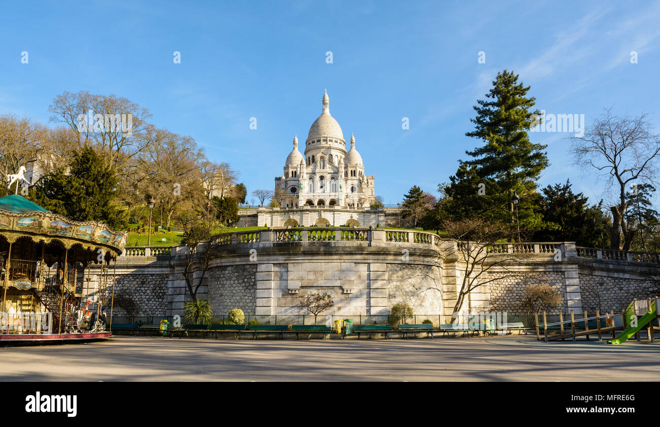 Vue panoramique sur la basilique du Sacré-Cœur de Paris à partir de la partie inférieure de la Louise Michel, avec un carrousel en premier plan au printemps. Banque D'Images