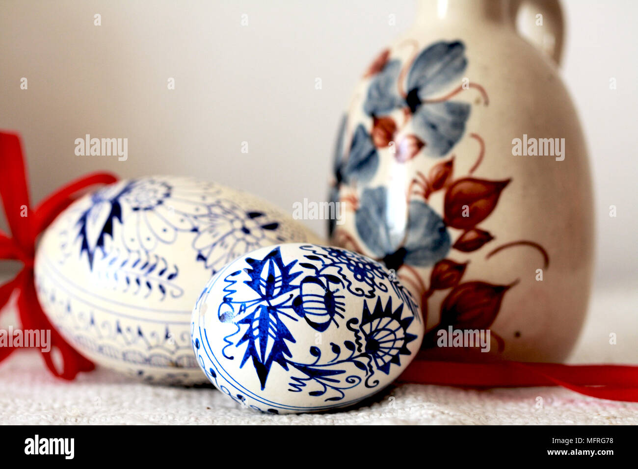 Bleu et blanc traditionnels oeufs de Pâques République Tchèque à côté d'un brown jug. Deux oignons bleu et blanc peint à la main de style oeufs de Pâques en République tchèque reste à côté d'une douleur à la main Banque D'Images