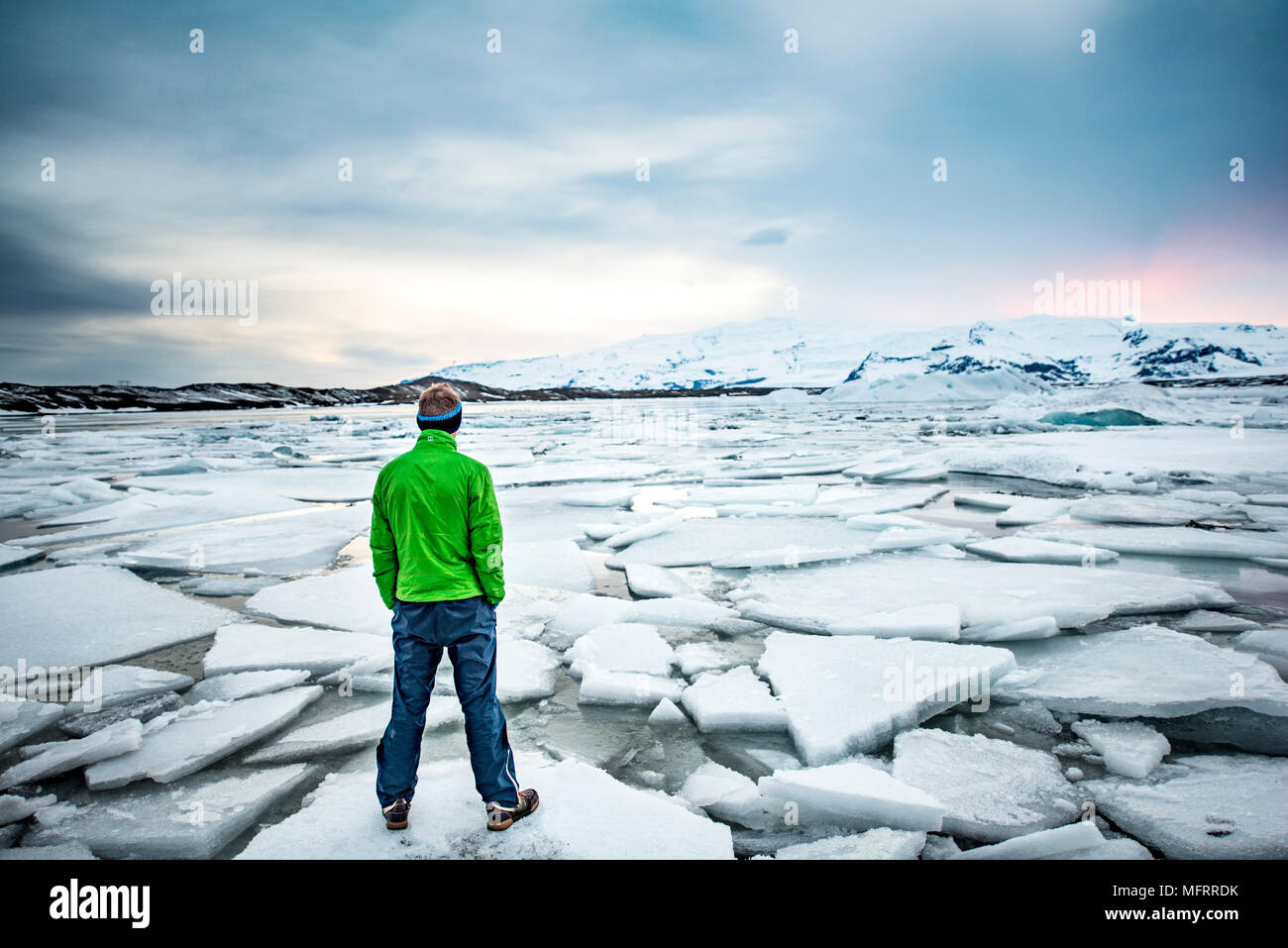 Randonneur sur un floe, glacier lagoon, le lac glaciaire Jökulsárlón, coucher de soleil, extrémité sud de l'Islande du sud-est, Vatnajökull Banque D'Images