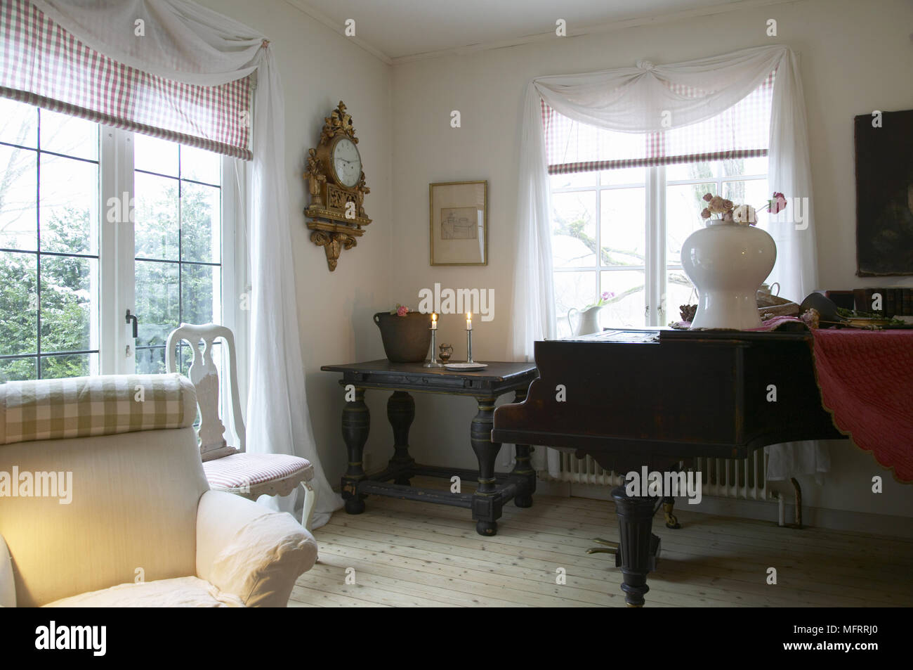 Salon suédois avec variété de meubles et son piano à côté de fenêtre. Banque D'Images