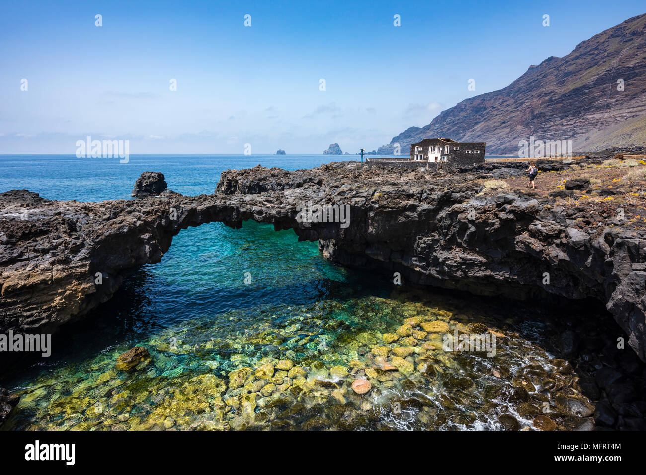 Black lava rock arch avec Hôtel Punta Grande, Las Puntas, El Golfo, El Hierro, Îles Canaries, Espagne dans l'arrière-plan Banque D'Images
