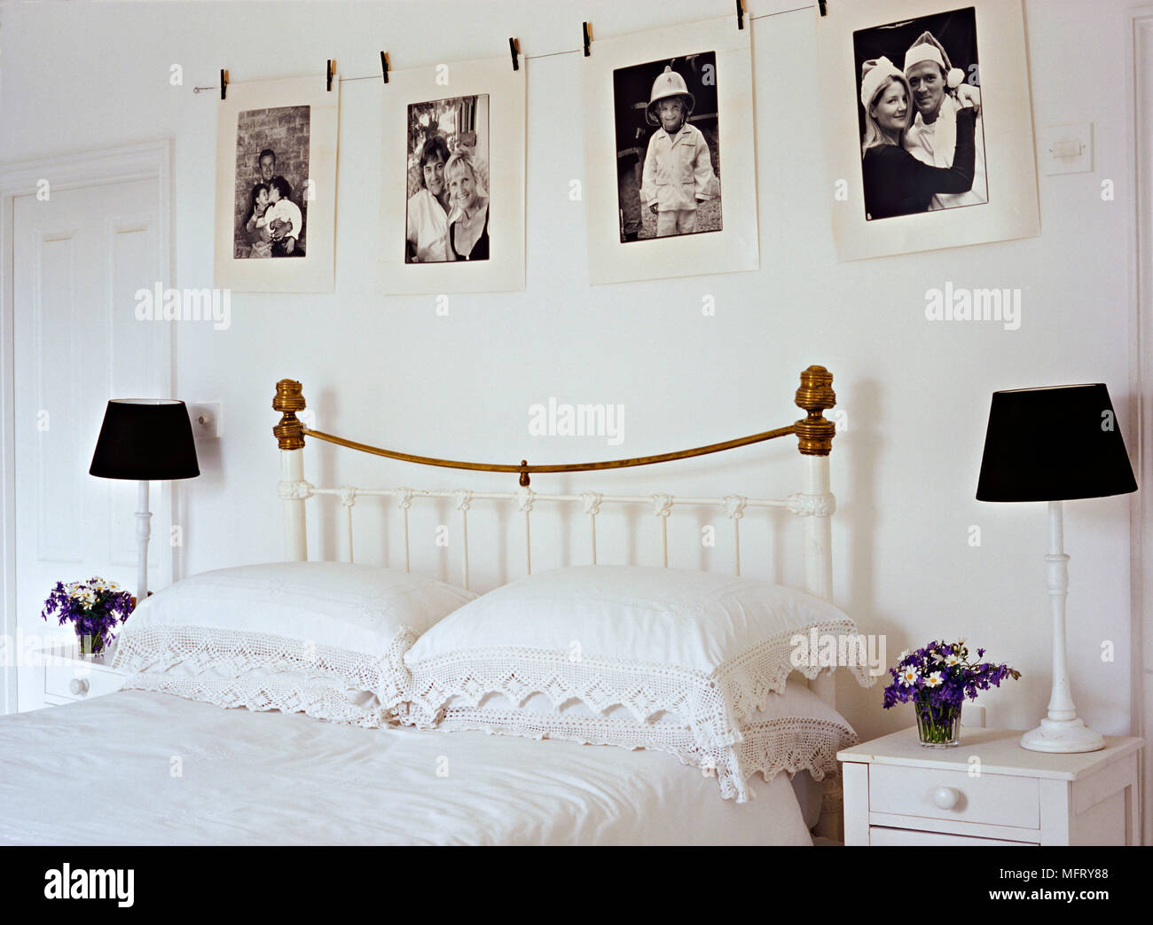 Un détail d'une chambre avec un neutre traditionnel en fer forgé peint et laiton avec lampes de chevet de lit Banque D'Images