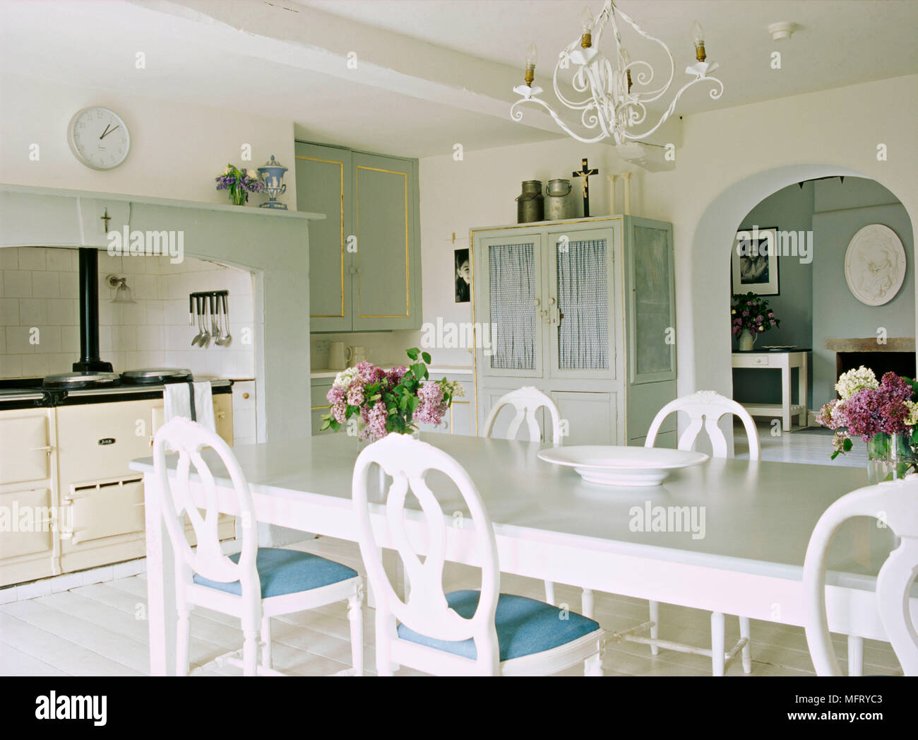 Un pays neutre cuisine-séjour avec cuisinière dans l'enfoncement peint en blanc table et chaises Gustavien Banque D'Images