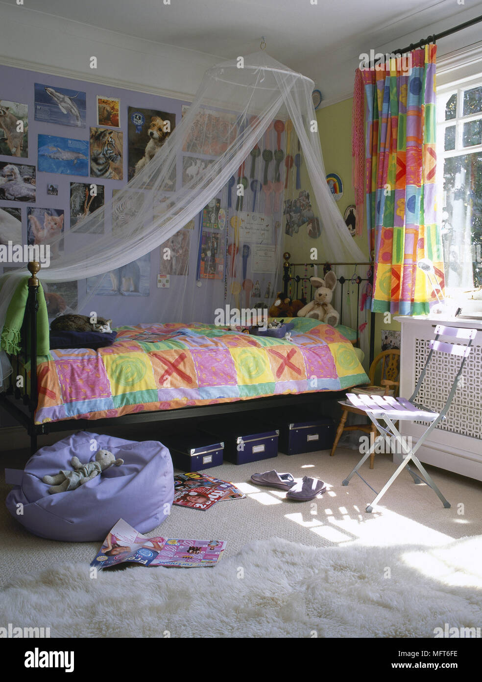 La chambre de l'enfant avec un lit en laiton, net, de l'auvent et la literie colorés avec des rideaux assortis. Banque D'Images