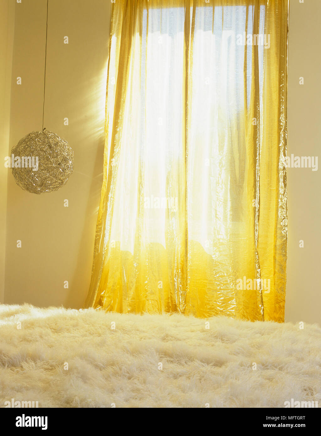 Rideaux d'or à la lumière de la fenêtre et plafond suspendu au dessus de lit Banque D'Images