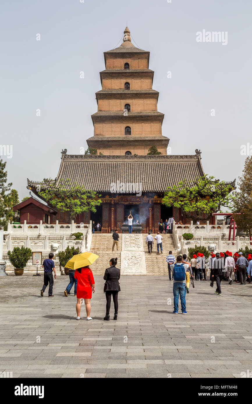 Les touristes visitent le Giant Wild Goose Pagoda, Xi'an, Chine. En face de la pagode un adorateur soulève un bâton d'encens et la fumée qui souffle dans le vent. Banque D'Images
