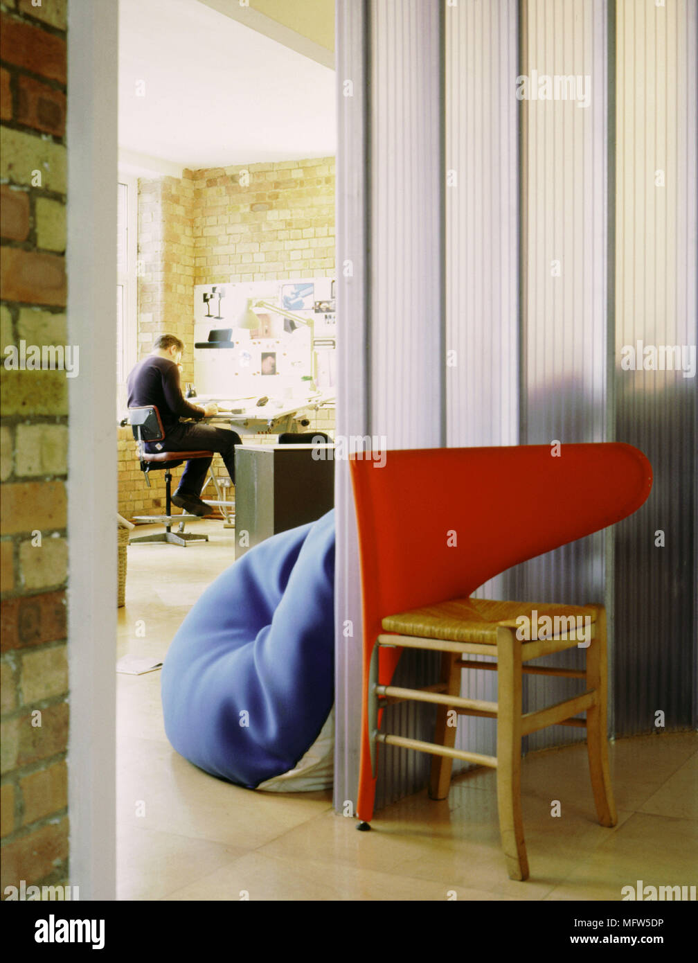 Vue de l'homme assis à table à dessin mur opaque chaise en bois panneaux intérieurs chambres modernes bureaux espaces Banque D'Images