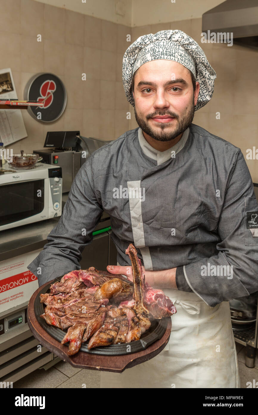 Yang chef italien montrant côte de boeuf gras grillé Banque D'Images