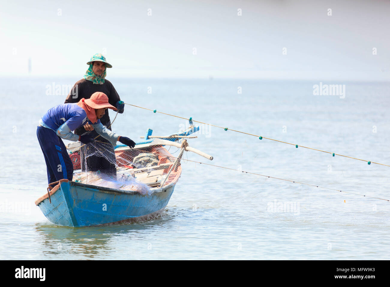 Les pêcheurs avec une distribution net dans la mer de Chine du Sud près de Clé, Kampot, Cambodge Banque D'Images