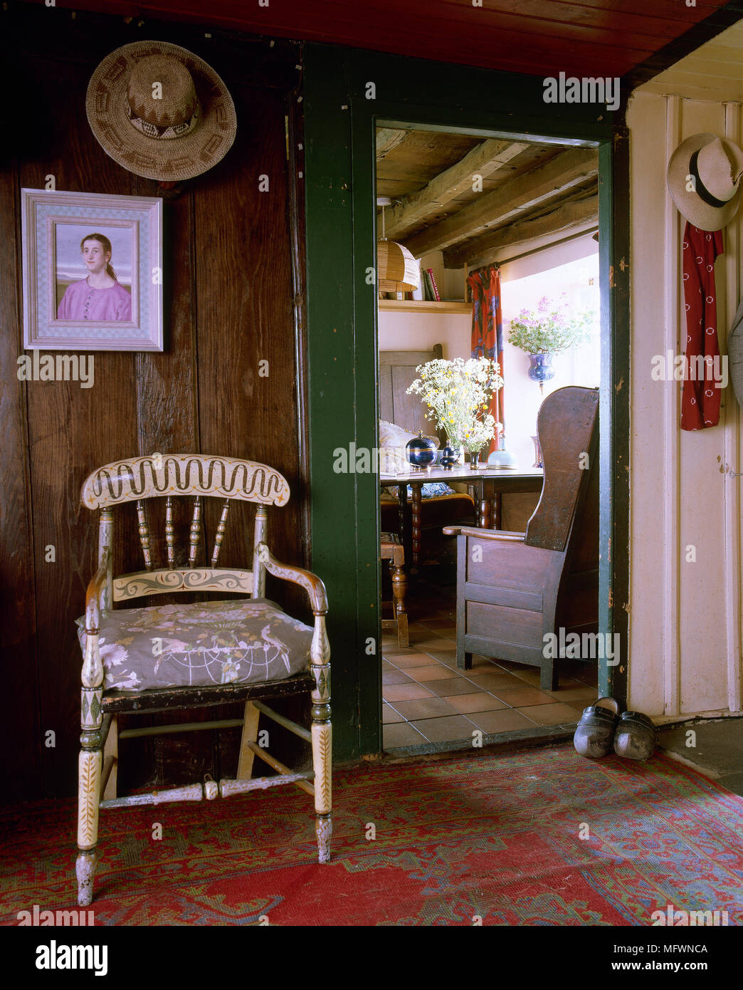 Pays rustique, couloir avec murs en bois, plancher en bois patiné, peint de plaisance président, et une porte ouverte à une salle adjacente. Banque D'Images