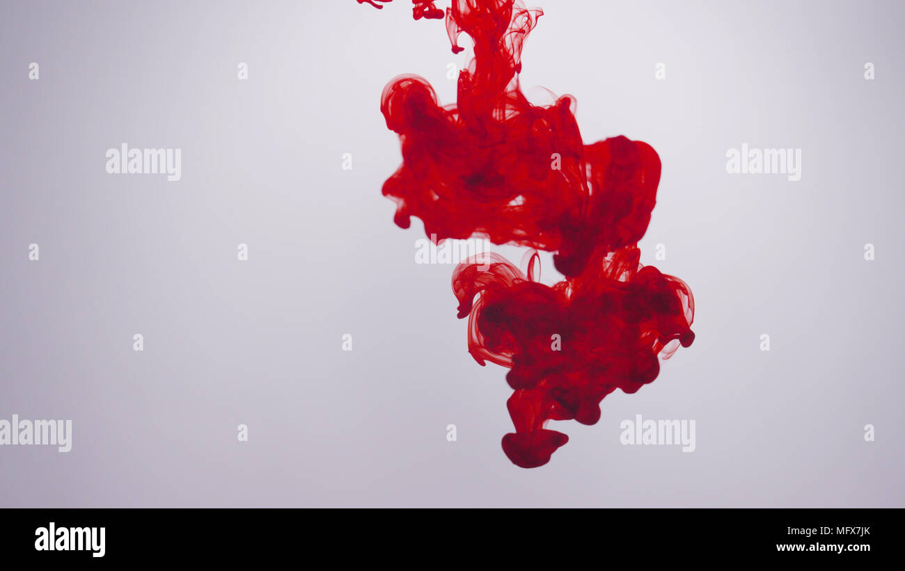 L'encre rouge/sang billows in front of white background Banque D'Images