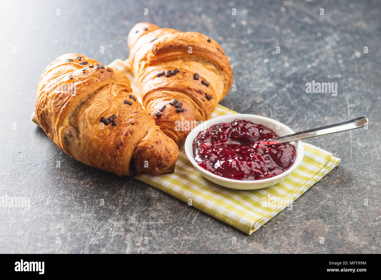 Deux croissants au chocolat les miettes et confiture. Banque D'Images