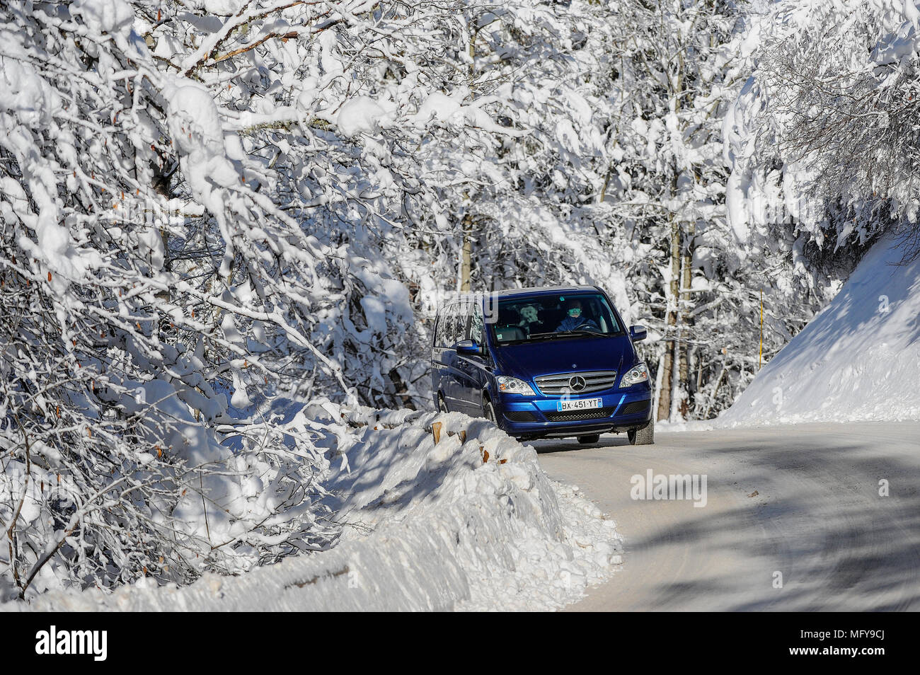 Un transfert minibus durs le long d'une route couverte de neige dans la station alpine de Courchevel. Banque D'Images