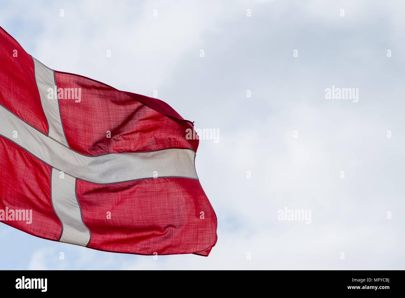 Drapeau national du Danemark dans le vent avec ciel bleu et nuages en arrière-plan Banque D'Images
