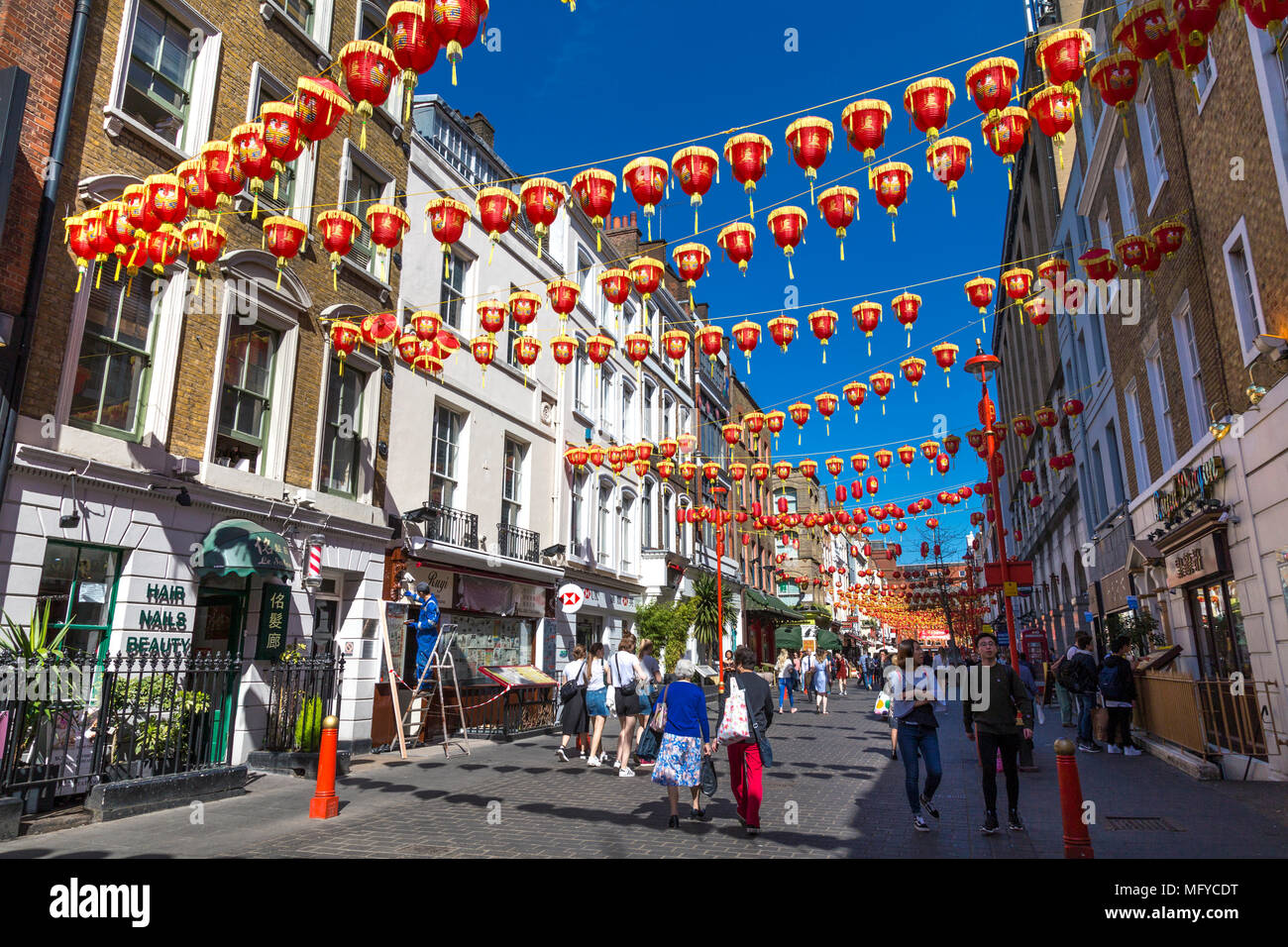 Le rouge et le jaune des lanternes chinoises suspendues au-dessus d'une rue à China Town, Londres, UK Banque D'Images