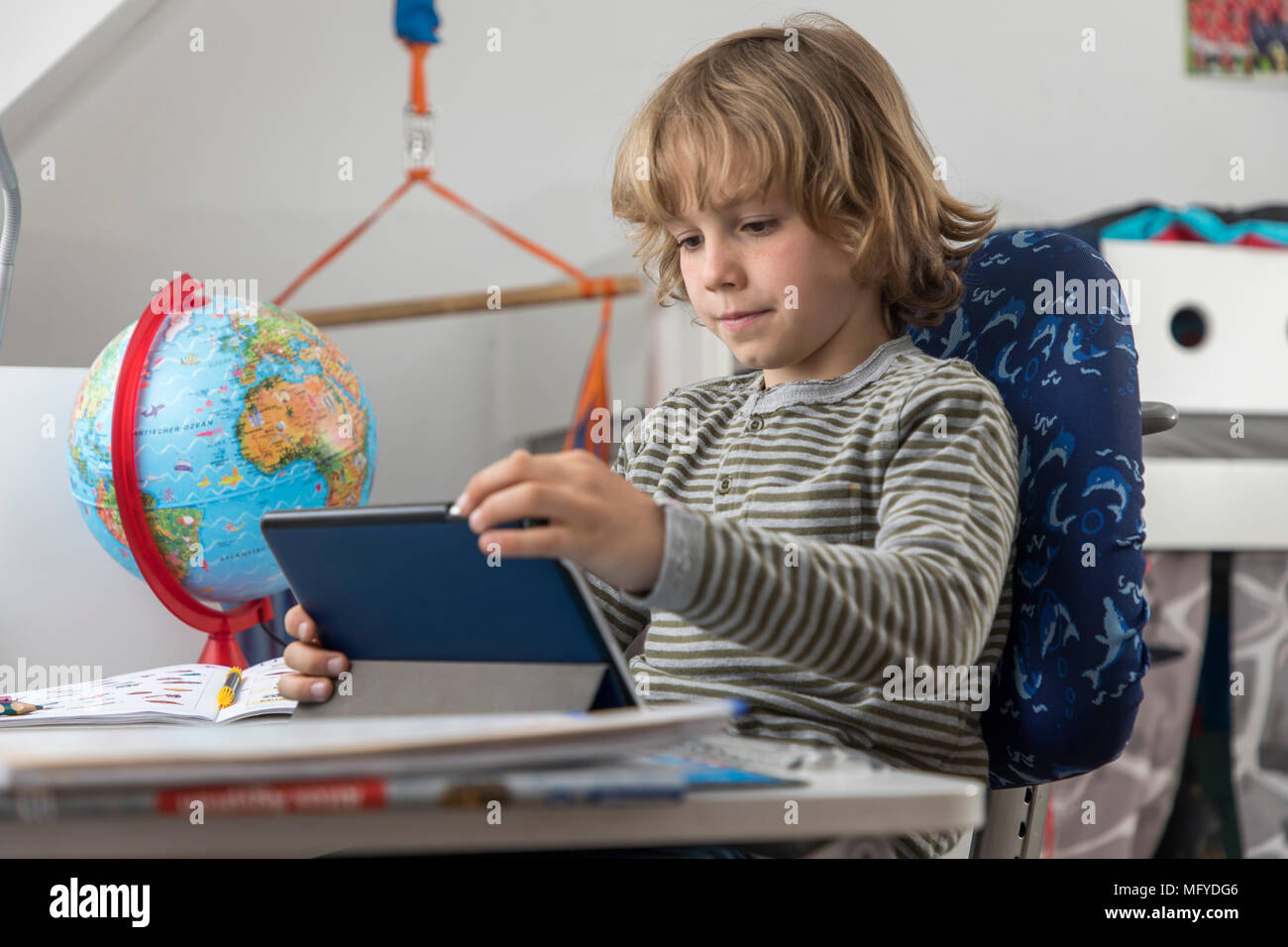 Garçon, école primaire, 8 ans, apprend à l'école à la maison, devoirs, n'utilise un ordinateur tablette pour l'apprentissage, Banque D'Images