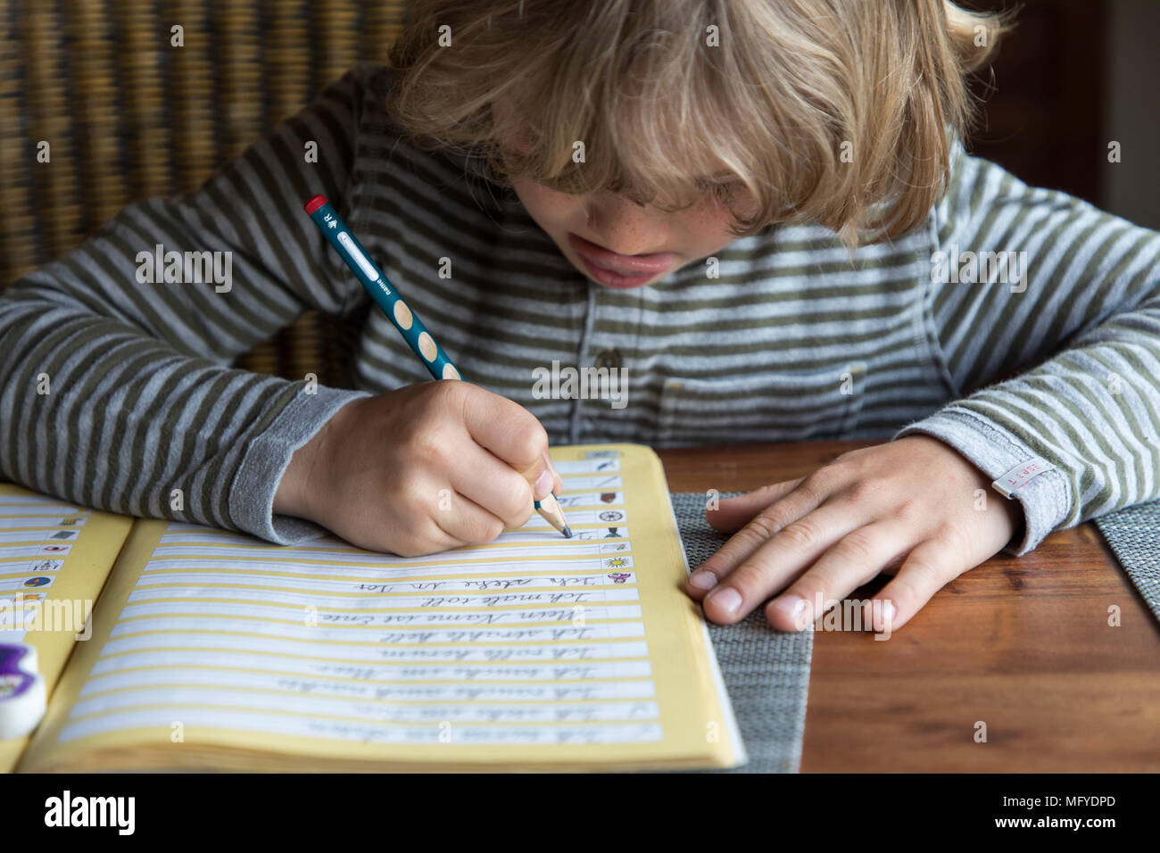 Garçon, école primaire, 8 ans, apprend à l'école à la maison, devoirs, exercices d'écriture ne Banque D'Images