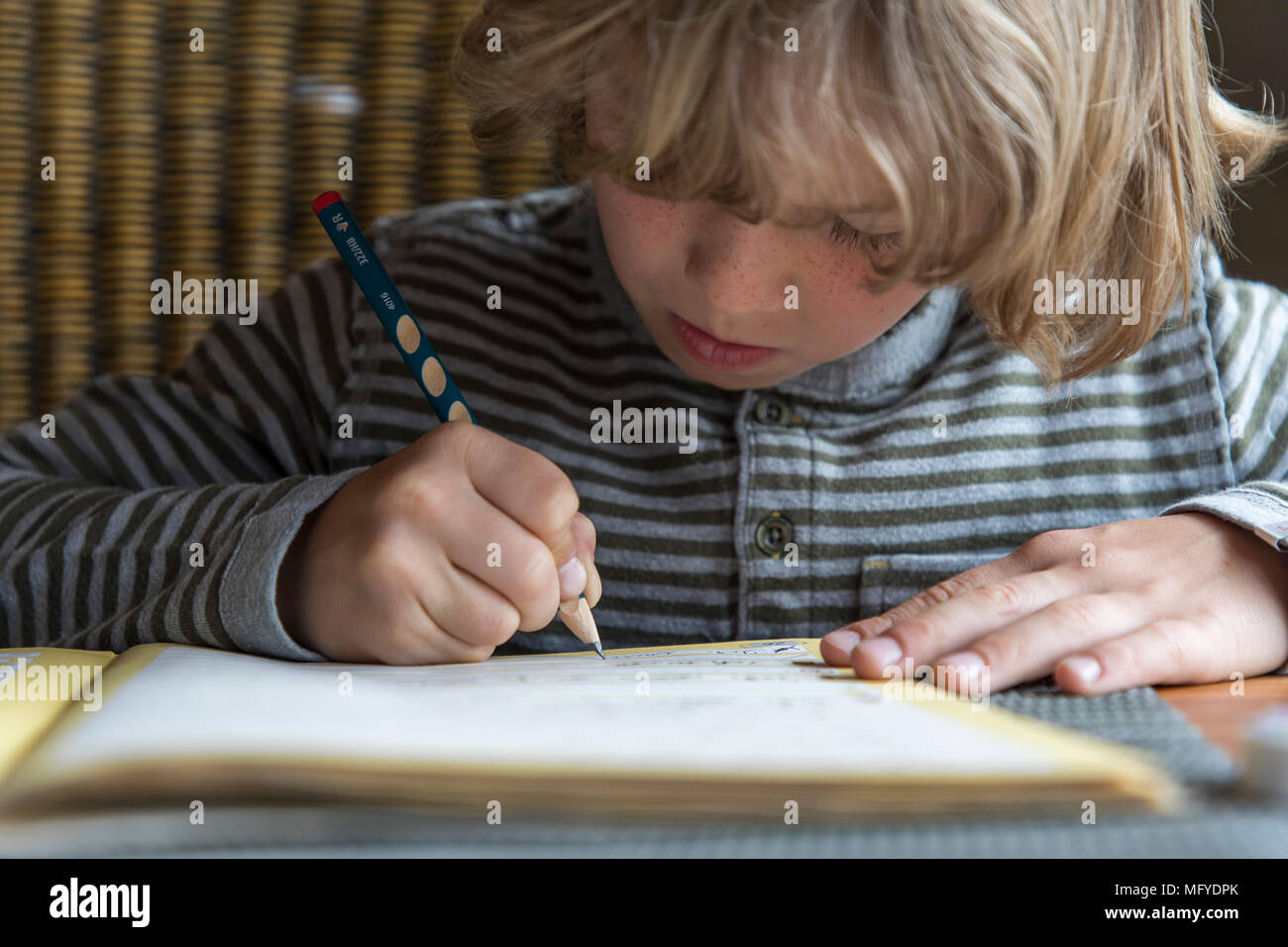 Garçon, école primaire, 8 ans, apprend à l'école à la maison, devoirs, exercices d'écriture ne Banque D'Images