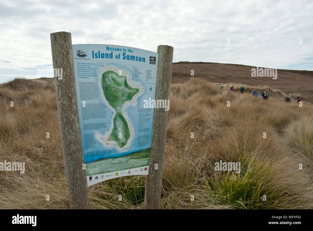 Grand panneau avec une carte et des informations sur l'île de Samson avec un sentier de marcheurs dans la distance de marche sur les dunes de sable. Banque D'Images