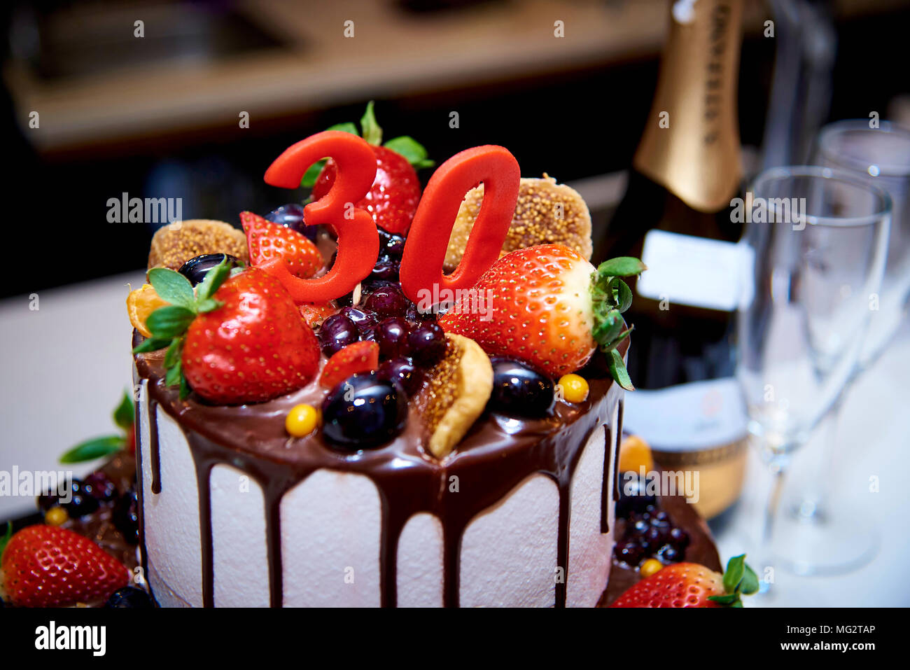 Un Gateau Blanc A Deux Niveaux Avec Des Fruits Et Du Chocolat Se Tient A Cote D Une Bouteille De Champagne Et Deux Bokalam Photo Stock Alamy