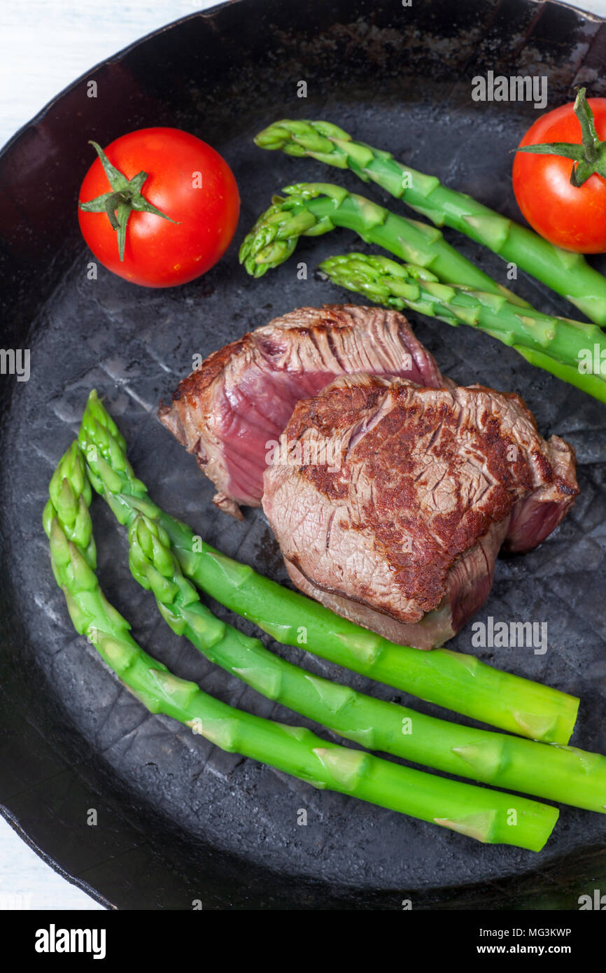 Pavé de boeuf et asperges vertes dans une casserole Banque D'Images