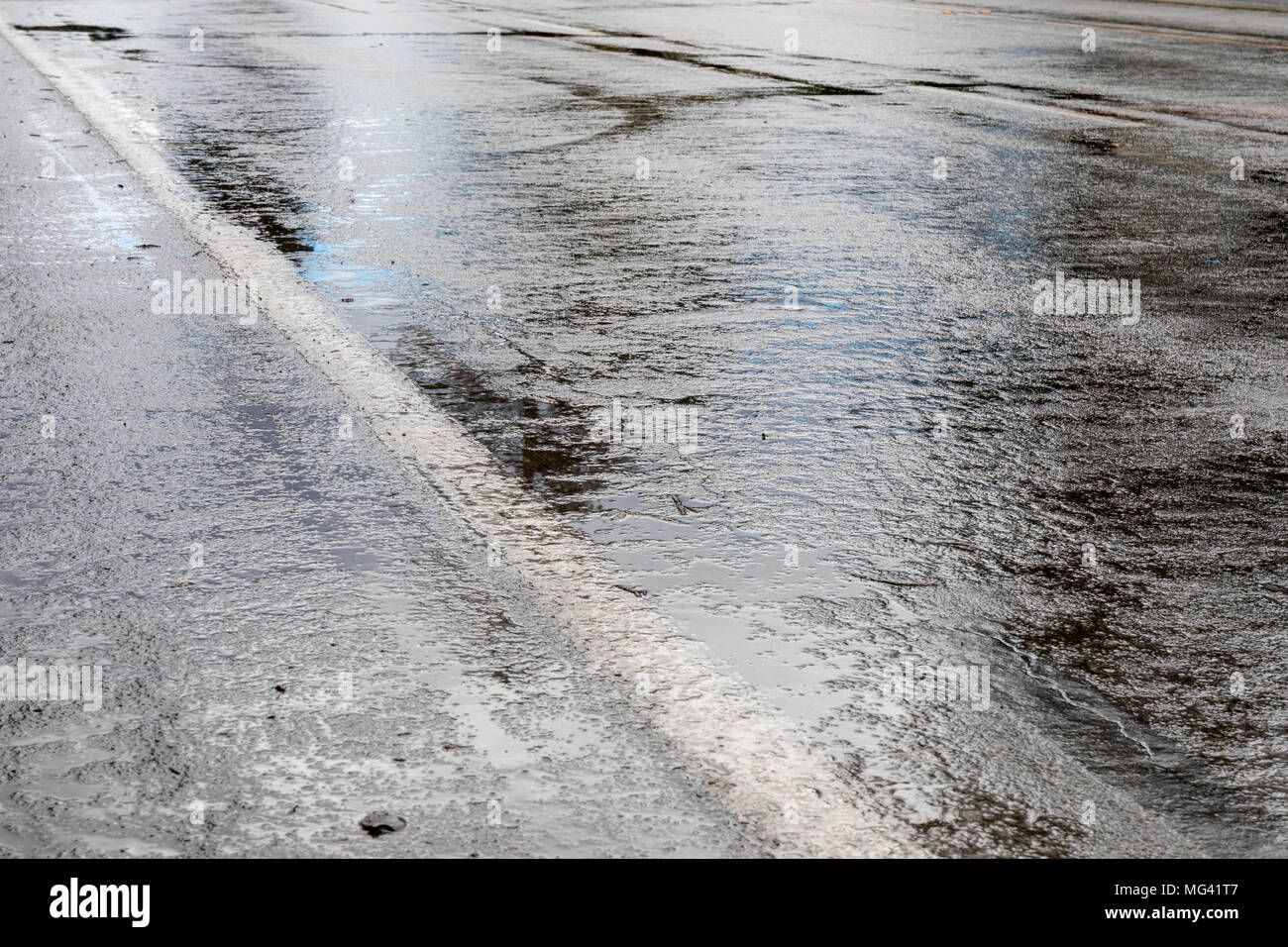 La pluie sur l'asphalte humide : la surface de la route Banque D'Images