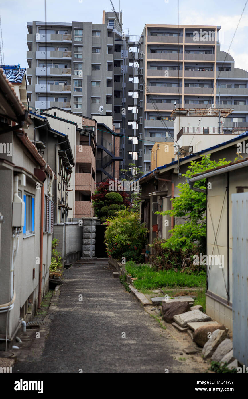 Petites maisons typiquement japonais devant des tours d'habitation typique Banque D'Images