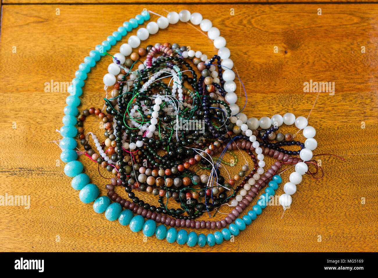 Beaucoup de fils de perles de diverses couleurs portant sur une table basse en bois Banque D'Images