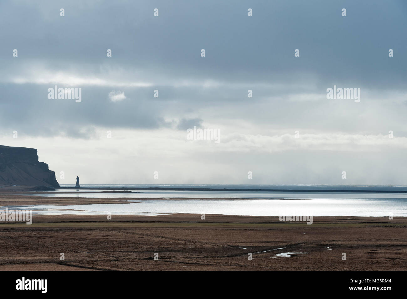 Près de Reynisfjara qui jouit, Vík, Sud de l'Islande. La plage de sable noir est une célèbre attraction touristique. L'une des piles de la mer de Reynisdrangar est visible sur la gauche Banque D'Images