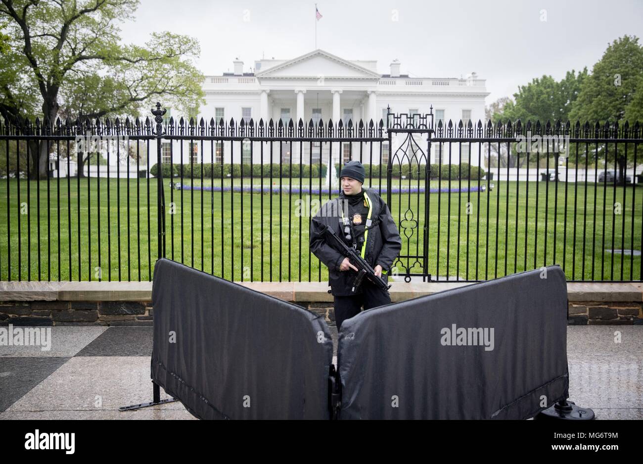 27 avril 2018, Washington, États-Unis : un agent des services secrets  debout sous la pluie avant que la Maison Blanche. La chancelière Merkel  (CDU) se réunit le président américain, Trump ici à