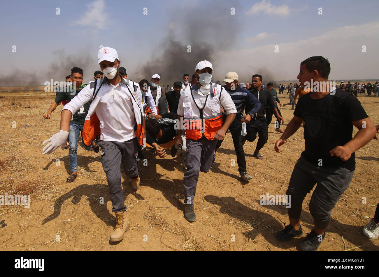 La bande de Gaza. Apr 27, 2018. Les médecins palestiniens transportent un homme blessé lors d'affrontements avec les troupes israéliennes sur la frontière Gaza-Israel, à l'est de Khan Younis, dans le sud de la ville de Gaza, le 27 avril 2018. Credit : Khaled Omar/Xinhua/Alamy Live News Banque D'Images