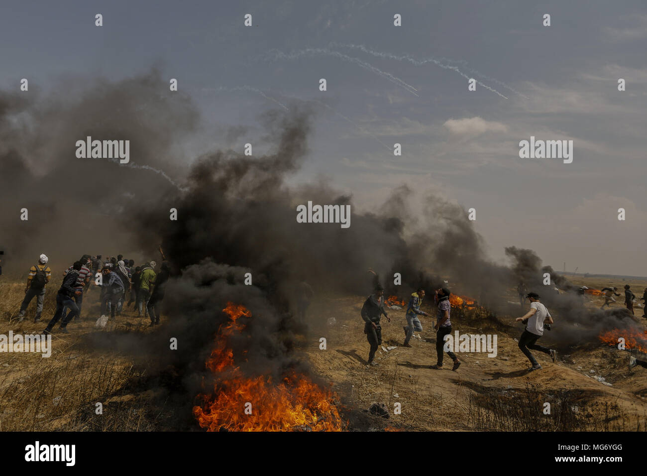 Khan Younis, dans la bande de Gaza. Apr 27, 2018. La fumée monte de pneus en feu, de gaz lacrymogène tiré par les forces de sécurité israéliennes de tomber sur des manifestants palestiniens lors d'affrontements le long de la frontière, Israel-Gaza à Khan Younis, dans la bande de Gaza, 27 avril 2018. Les Palestiniens protestent pour le 5ème vendredi d'une ligne dans le cadre d'une période de six semaines de protestation, le long de la frontière Gaza-Israel, à la demande de retourner dans leurs foyers qu'ils ont été expulsés de lors de la guerre de 1948 qui a marqué la création d'Israël. Credit : Mohammed Talatene/dpa/Alamy Live News Banque D'Images