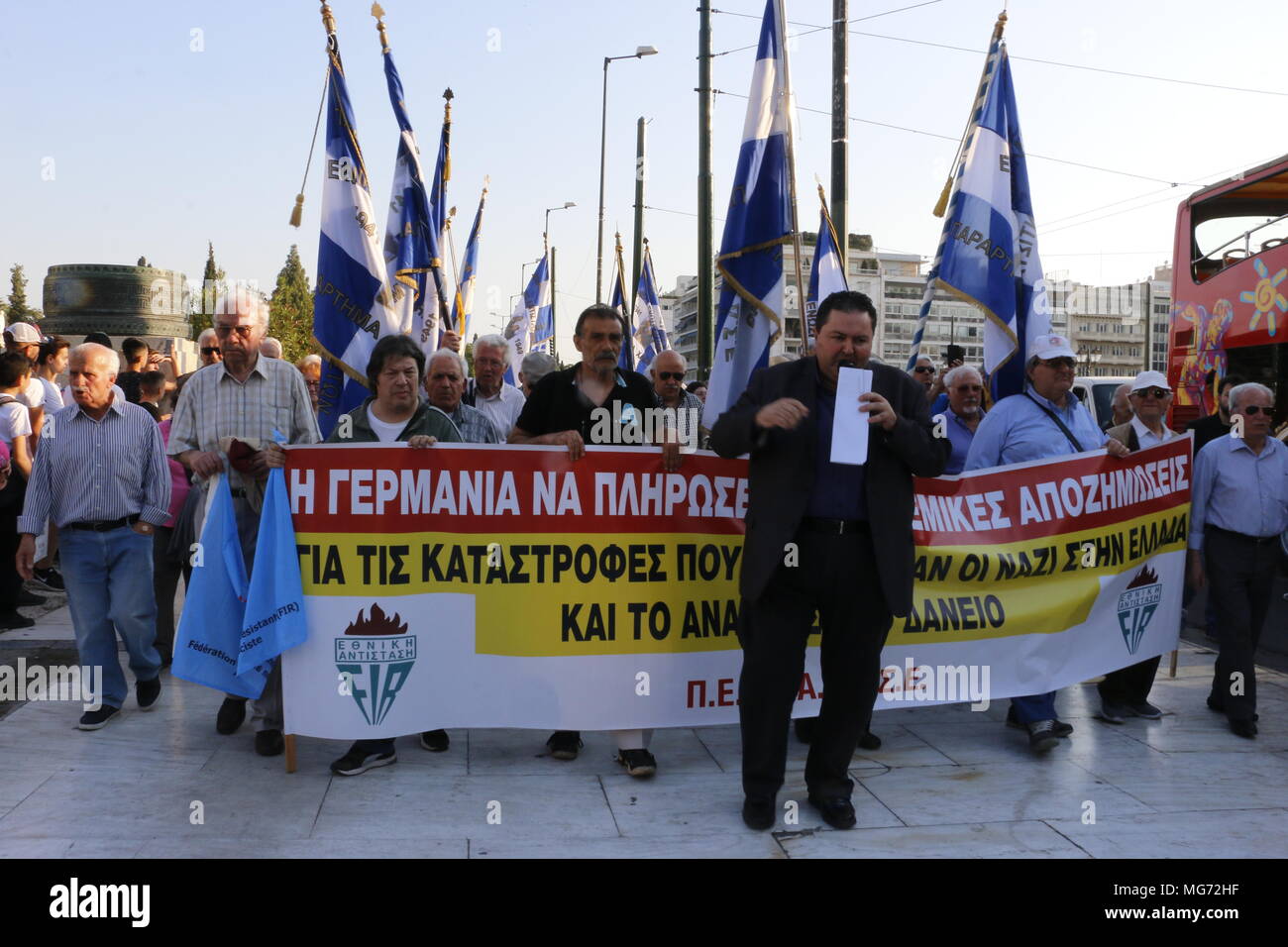 Vu les manifestants holding banner et d'un drapeau pendant la démonstration. Mot grec War 2 Les membres font preuve de résistance à Athènes exigeant de l'Allemagne à verser une indemnité de guerre de l'Allemagne nazie vers la Grèce. Banque D'Images