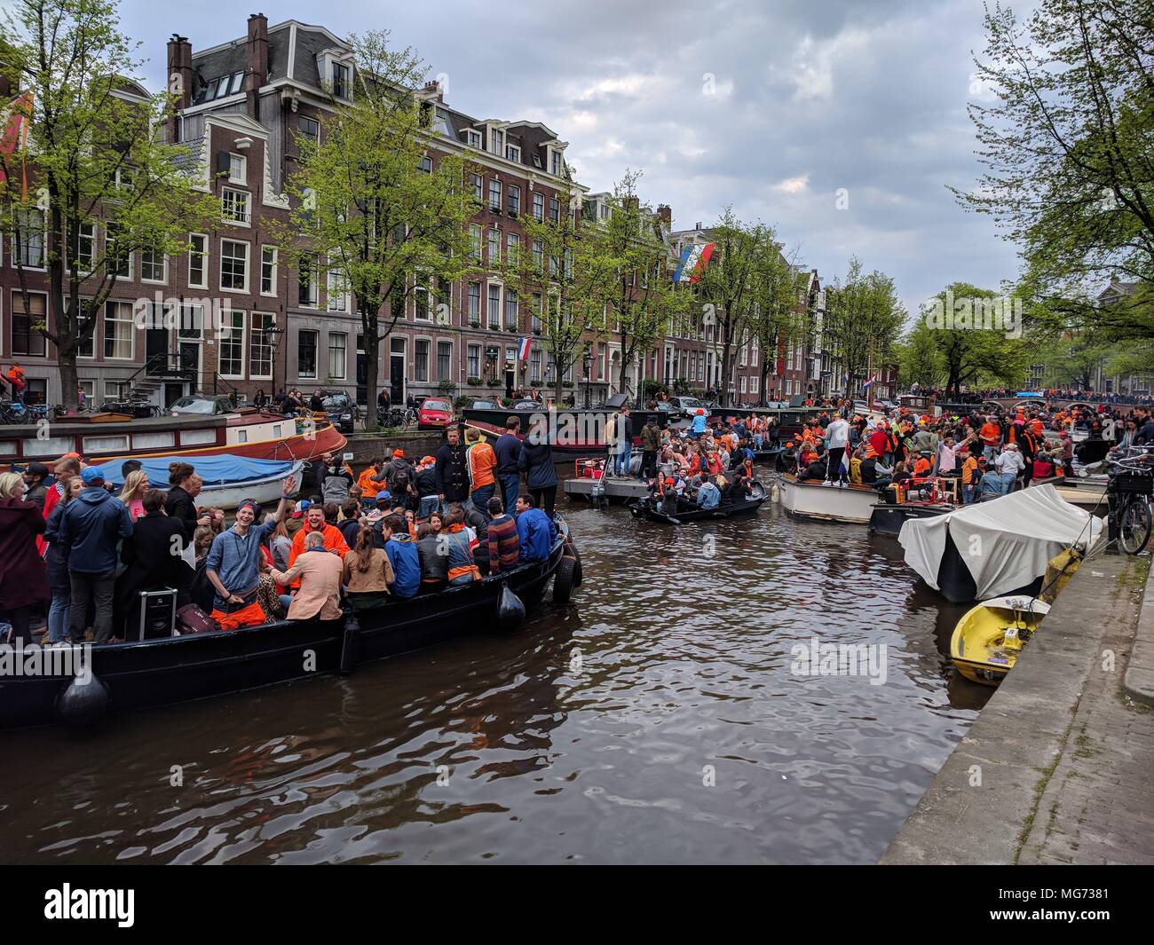Amsterdam, Pays-Bas - 27 Avril 2018 : la fête du Roi - ressemble à un embouteillage sur le canal, les personnes ayant un bon temps à profiter de leurs boissons sur le bateau ; la Fête du Roi (autrefois le jour de la Reine) festivités d'inviter les habitants et les visiteurs à profiter du plaisir en plein air. Dans les rues, les canaux, les parcs et partout ailleurs, la ville regorge d'orange comme les habitants de la rue profitez de la plus grande partie de l'année. ; Crédit : Bala Divakaruni/Alamy Live News Banque D'Images