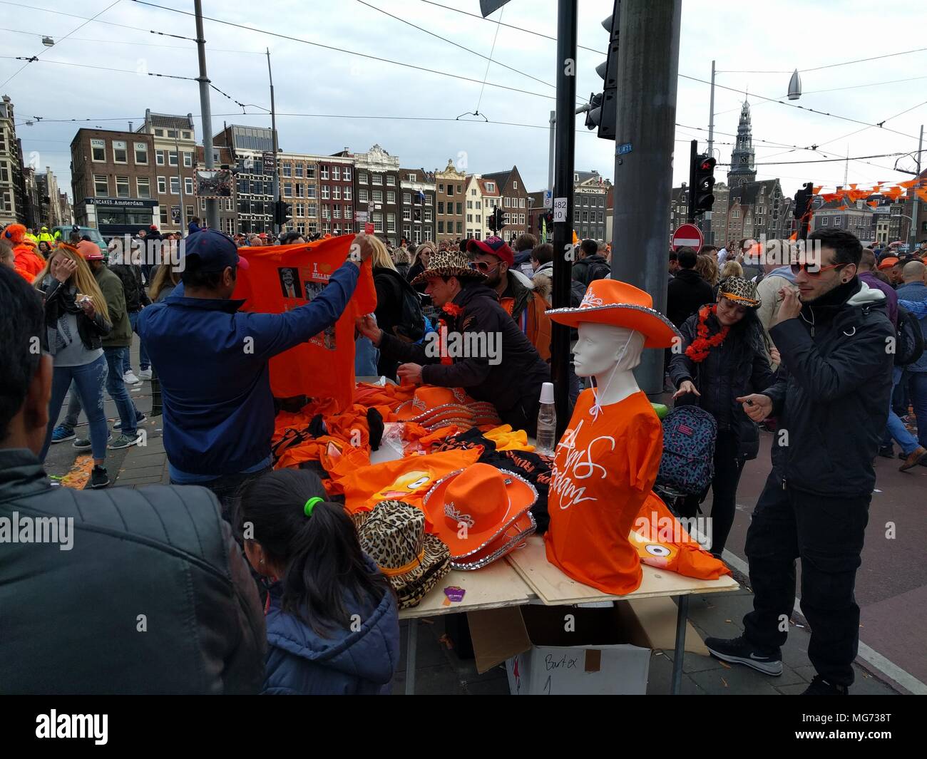 Amsterdam, Pays-Bas - 27 Avril 2018 : la fête du Roi - vendeur de rue, la vente d'orange ; la Fête du Roi (autrefois le jour de la Reine) festivités d'inviter les habitants et les visiteurs à profiter du plaisir en plein air. Dans les rues, les canaux, les parcs et partout ailleurs, la ville regorge d'orange comme les habitants de la rue profitez de la plus grande partie de l'année. ; Crédit : Bala Divakaruni/Alamy Live News Banque D'Images