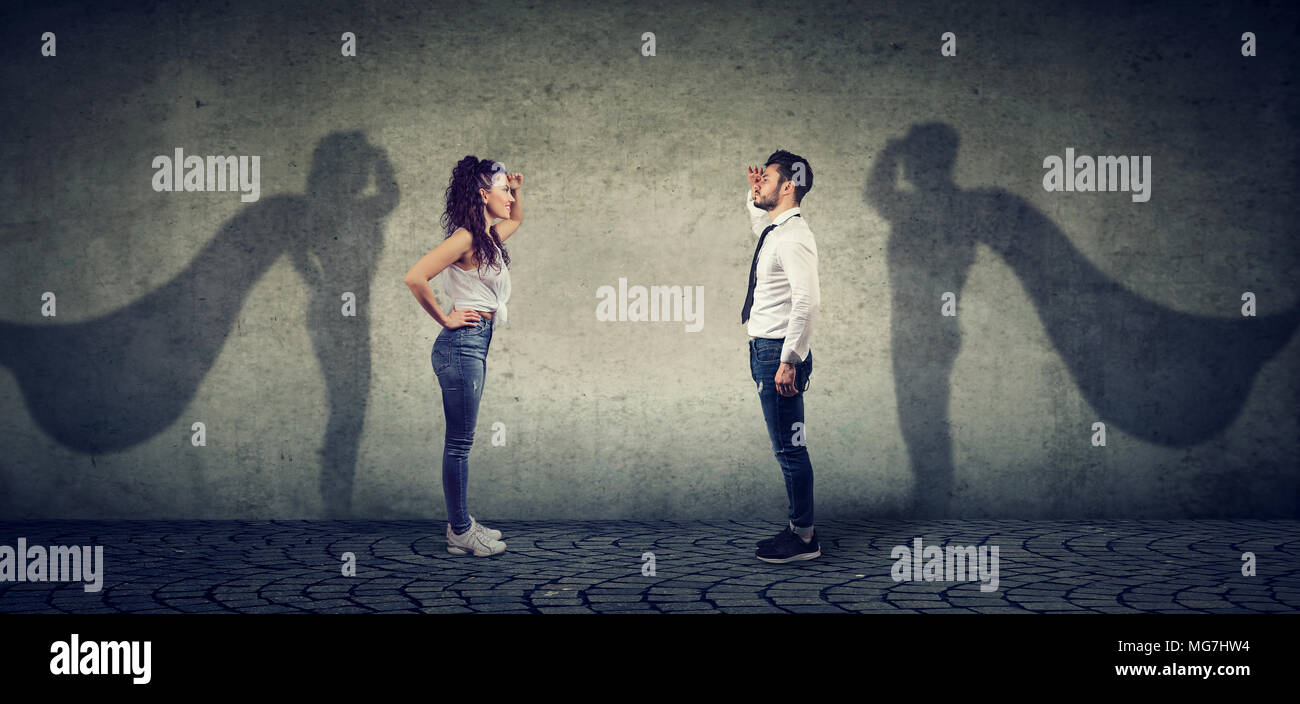 Vue latérale d'un homme et femme d'imaginer d'être un super héros à la aspirait. Banque D'Images