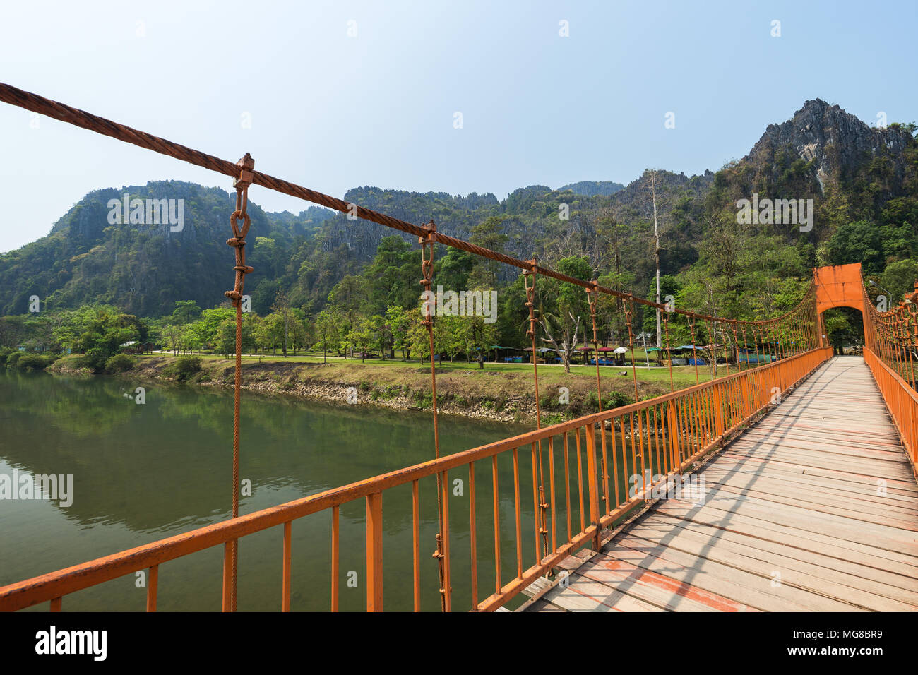 Suspension Orange passerelle sur la rivière Nam Song et pittoresques montagnes karstiques de calcaire près de Tham Chang (ou Jang ou Jung) Grotte à Vang Vieng, Laos. Banque D'Images