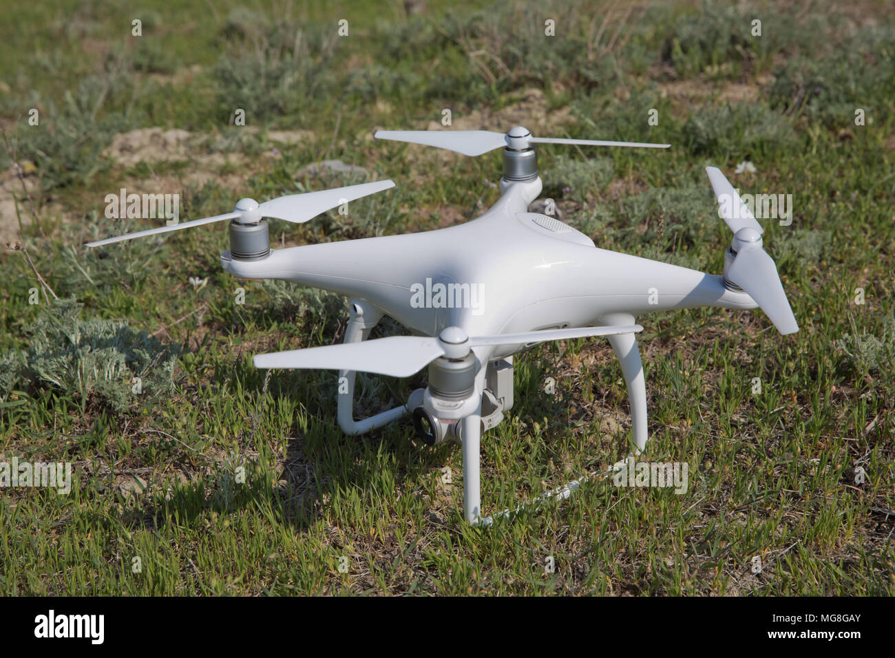 Bourdon blanc avec appareil photo numérique flying in sky sur la montagne  Drone avec une haute résolution appareil photo numérique. Drone avec  appareil photo dans l'herbe se préparent à voler Photo Stock -
