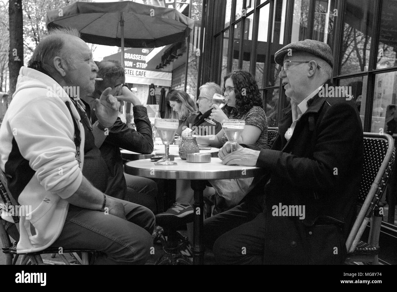 Deux personnes âgées messieurs français parler plus d'un verre dans un café de la rue sur l'Avenue de Suffren, près de la Tour Eiffel, Paris Banque D'Images