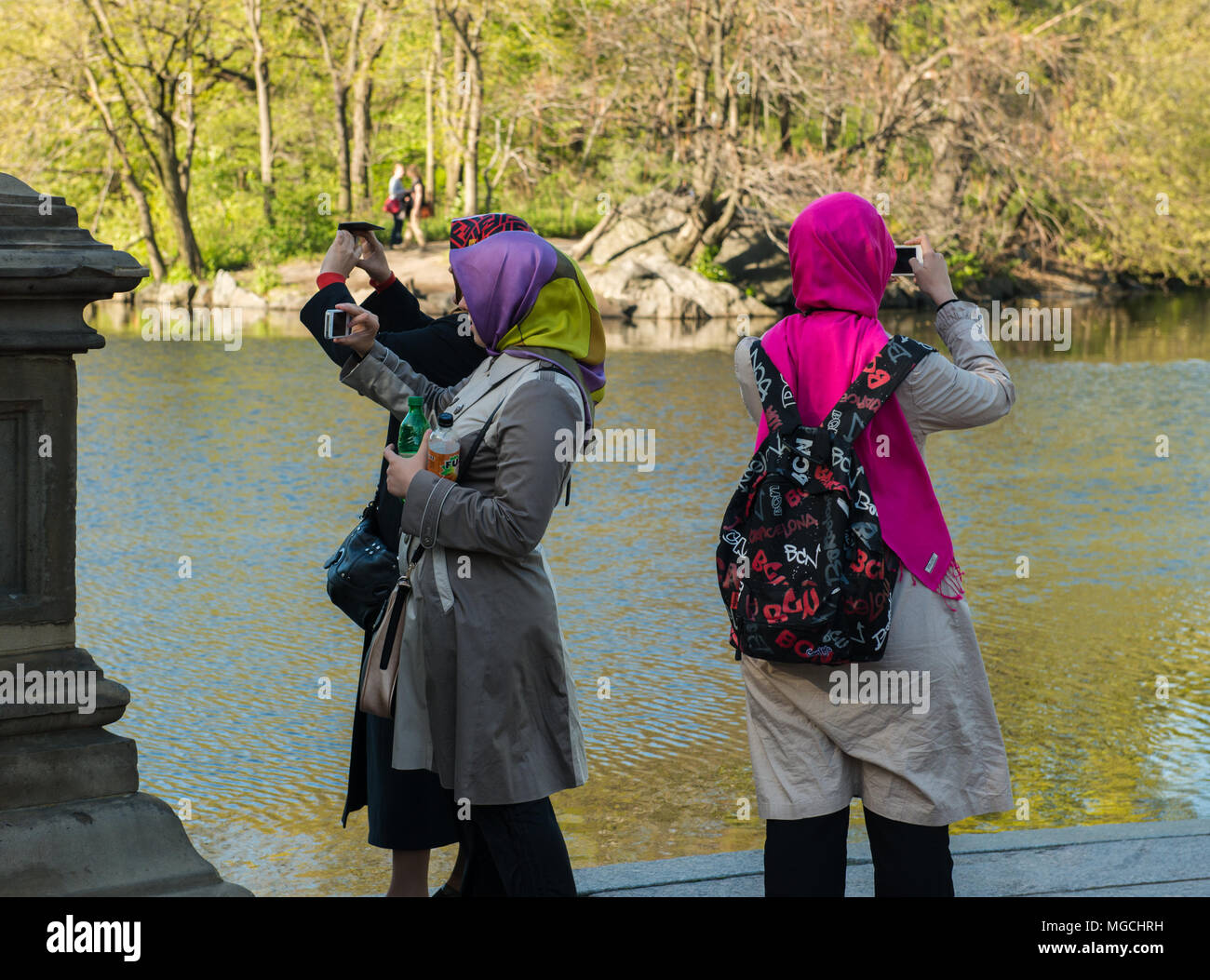 Trois femmes, le port du foulard coloré, de prendre des photographies dans Central Park, New York City, USA Banque D'Images