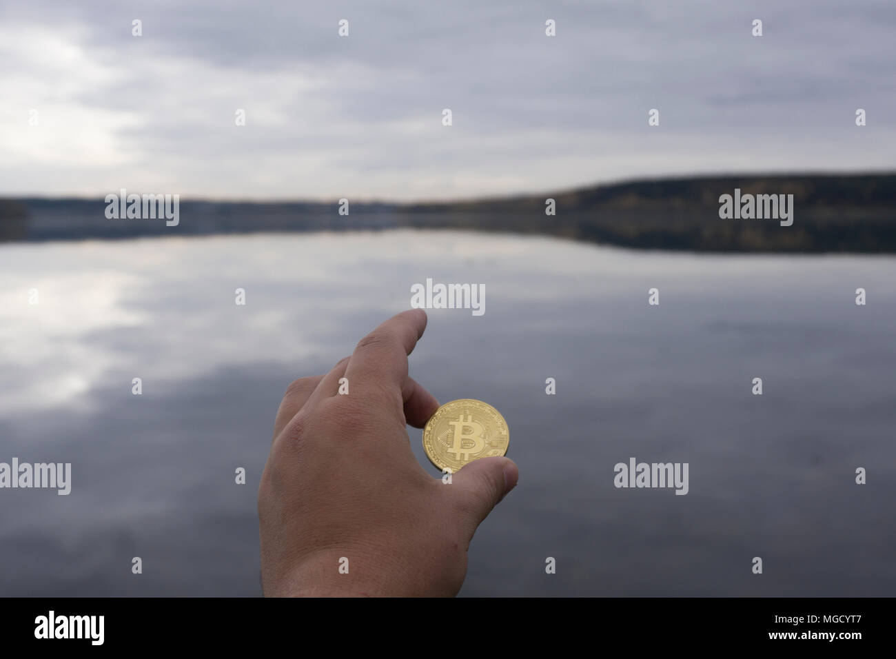 Les Bitcoins sont dans la main sur le fond de l'eau Banque D'Images