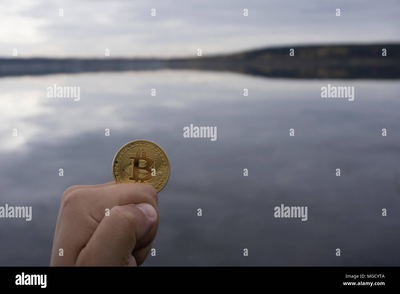 Les Bitcoins sont dans la main sur le fond de l'eau Banque D'Images