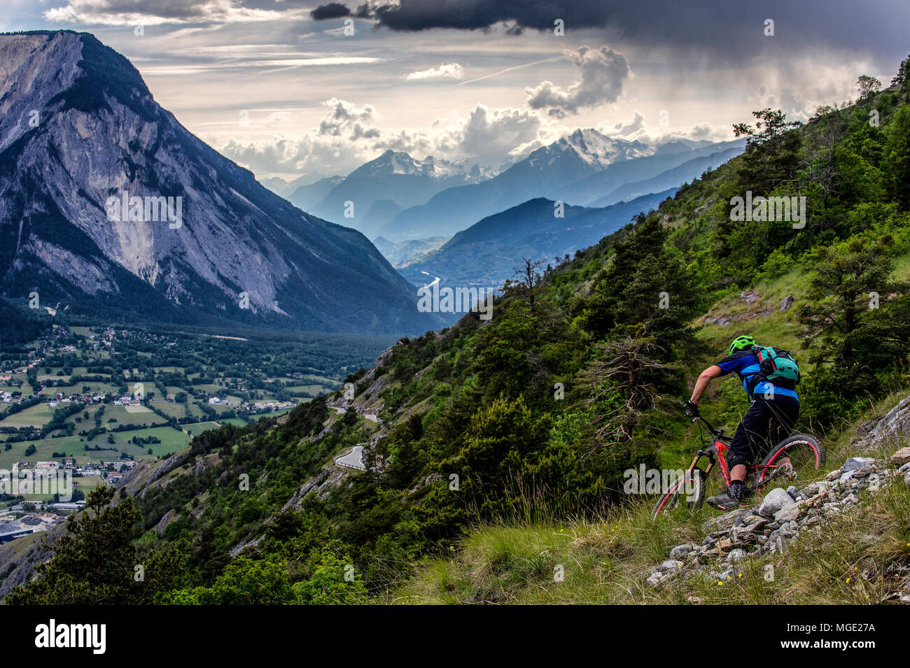 Un homme monte un vtt haut au-dessus de la vallée, près des villes de Gampel et Jeizinen dans le Valais Suisse. Banque D'Images